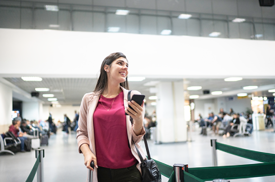 woman in airport happy after a customer experience transformation
