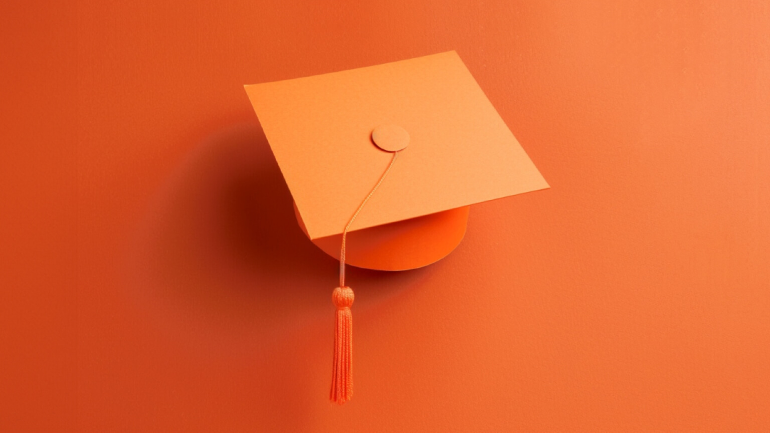 graduation cap on orange background, symbolizing looking for a job