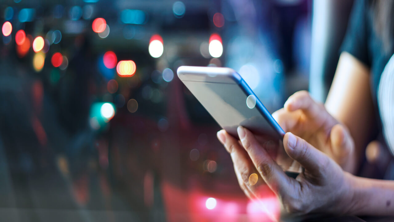 hand holding phone, a cover for this case study on an online gaming company's customer experience digital transformation